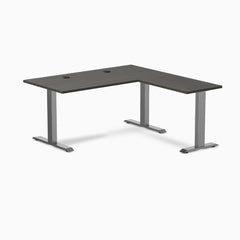 Burnished wood laminate L-shape office desk with space gray steel frame and grommets.