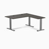 Burnished wood laminate L-shape office desk with space gray steel frame and grommets.