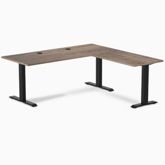 Desky Zero Laminate L-Shape Office Desk in Natural Walnut with matte black steel frame and grommets.