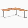 Prime Oak L-shape office desk with gray steel frame, grommets, and minimalist design.