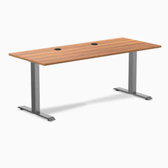 Desky Zero fixed height office desk with Prime Oak laminate top, two grommets, and Space Gray steel frame.