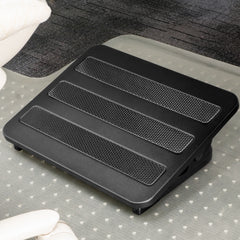 Black Desky Classic Foot Rest with three textured non-skid panels, on a clear mat over dark carpet.