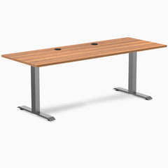 Desky Zero fixed-height office desk with Prime Oak laminate top, Space Gray steel frame, and two grommets.