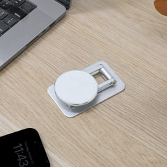 Phone holder on a wooden desk with a laptop and smartphone in the background