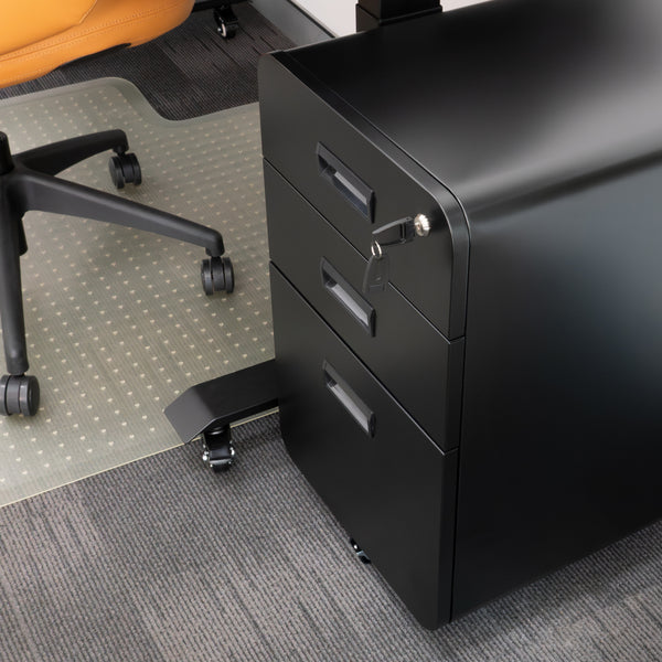 Black steel Desky 3-drawer mobile filing cabinet with rounded edges, key in lock, next to an office chair.