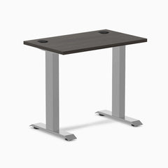 Desky Zero Mini fixed-height desk with burnished wood top, gray frame, and two grommets.