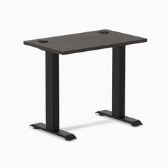 Desky Zero Mini sit-stand desk with burnished wood top, matte black legs, and grommets.