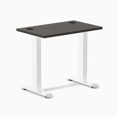 Desky Zero Mini fixed-height desk with burnished wood top, white legs, and two grommets.