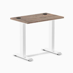 Desky Zero Mini desk with natural walnut top, white fixed-height legs, and two black grommets.