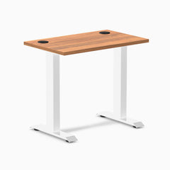Desky Zero Mini fixed-height desk with Prime Oak top, white legs, and black grommets.