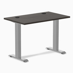 Desky Zero Mini sit-stand desk with burnished wood top, gray legs, and grommets.