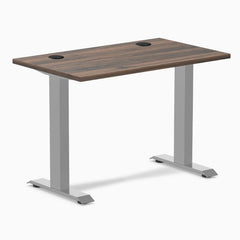 Desky Zero Mini fixed-height desk with Jarrah Legno top, gray legs, and two grommets.