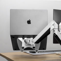 Silver laptop mounted on a black Desky universal laptop mount with a white VESA arm.