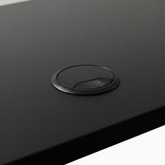 Black grommet hole on black desk