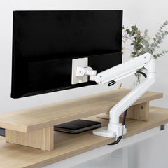 White Desky Heavy Duty Ultrawide Monitor Arm securely holding a large black monitor on a light wood desk.
