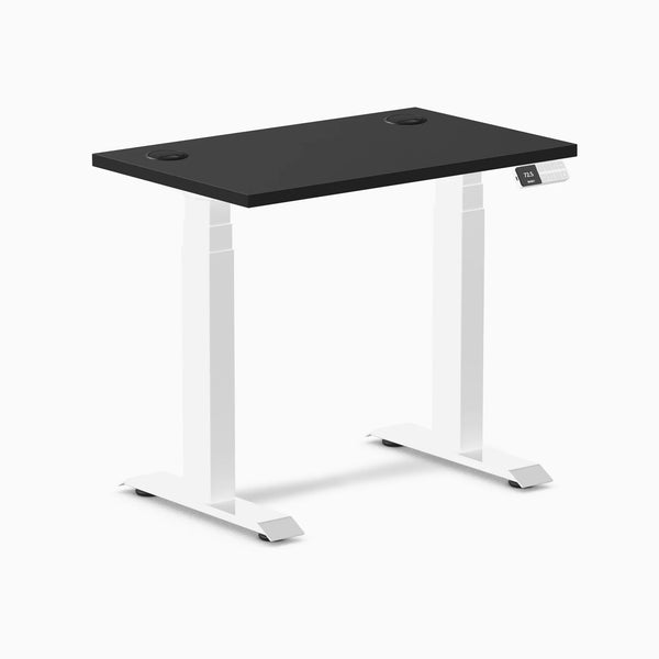 Black 32x20 inch Desky Dual Mini sit-stand desk with white frame and grommets.