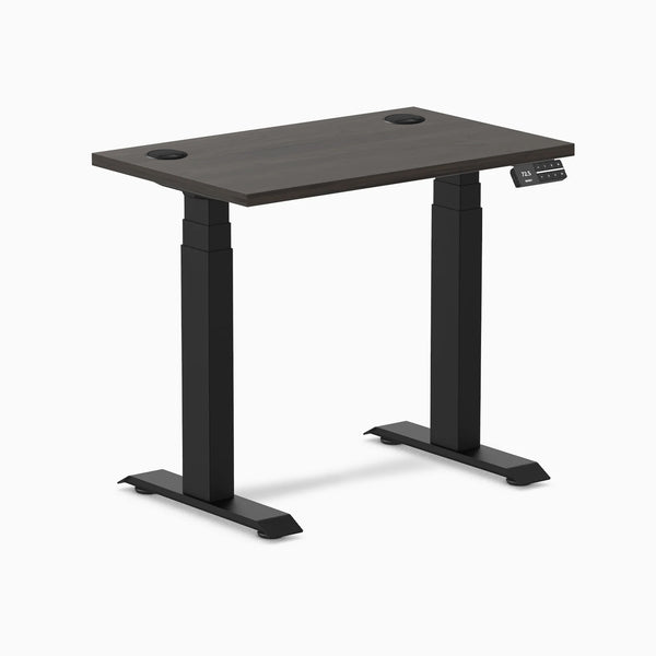 Compact Desky Dual Mini sit-stand desk with burnished wood top, matte black frame, and grommets.