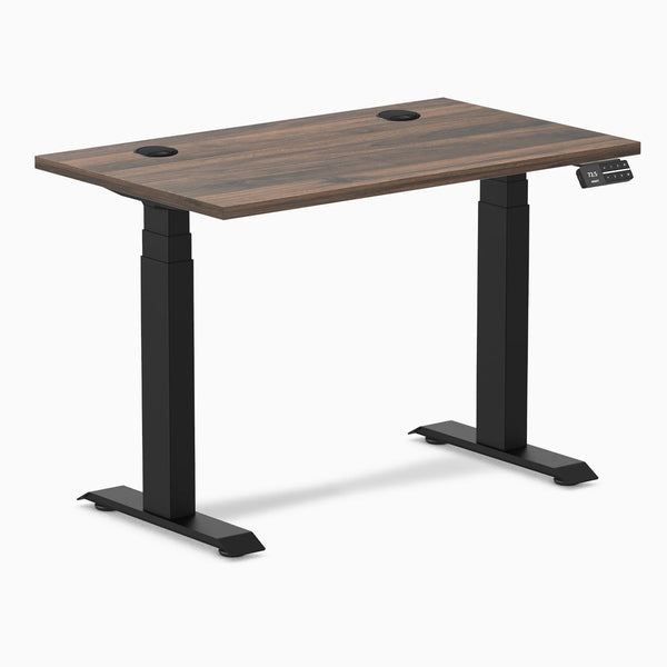 Desky Dual Mini sit-stand desk with Jarrah Legno top, matte black legs, and grommets.