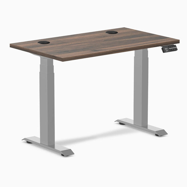 Desky Dual Mini sit-stand desk with Jarrah Legno top, gray legs, and grommets.