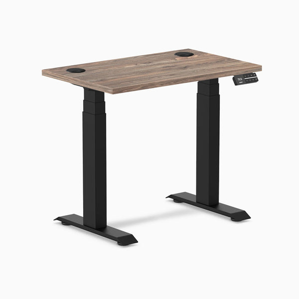 Desky Dual Mini sit-stand desk with natural walnut top, 32x20 inches, black matte frame, and grommets.