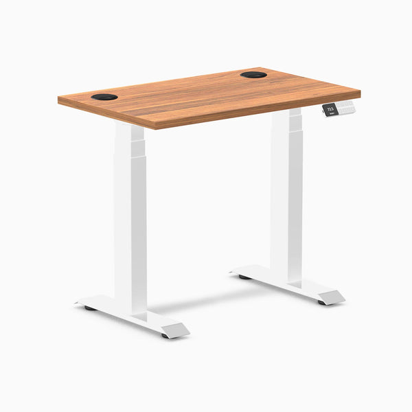 Desky Dual Mini sit-stand desk with Prime Oak top, white frame, and grommets.