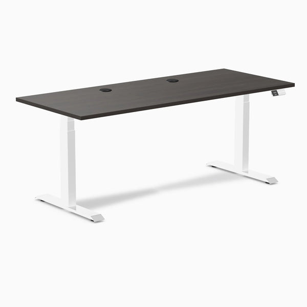 Desky Dual sit-stand desk with burnished wood laminate top, white frame, and two grommets.