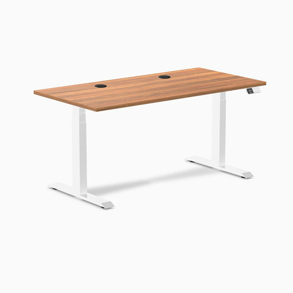 Desky Dual sit-stand desk with Prime Oak laminate top, white frame, and two black grommets.