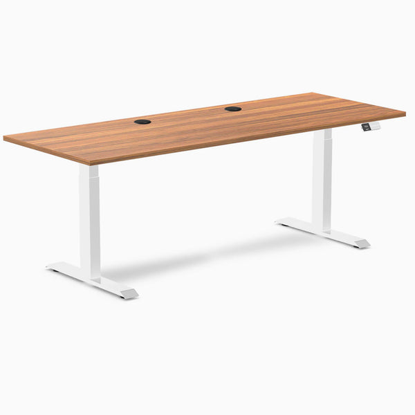 Desky Dual sit-stand desk with Prime Oak laminate top, white frame, and two grommets.