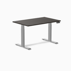 Desky Dual Laminate Sit Stand Desk with a dark wood-grain top and silver adjustable legs.