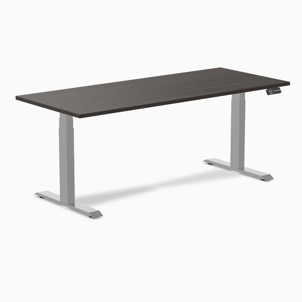 Desky Dual Laminate Sit Stand Desk with dark wood top and silver adjustable legs, featuring a control panel.