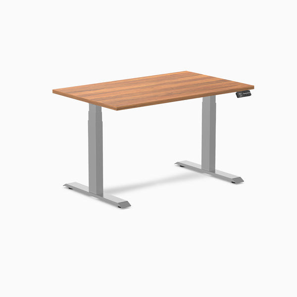 Desky Dual Custom Laminate Sit Stand Desk with a warm wood-grain top and silver adjustable legs.