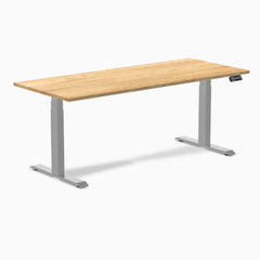 Desky Dual 72x30 inch White Oak hardwood sit-stand desk with gray legs and control panel.
