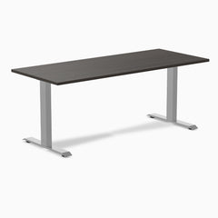 Desky Zero fixed-height office desk with dark laminate top and silver steel frame.