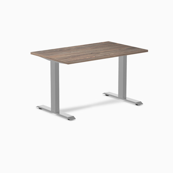 Desky Zero fixed-height office desk with a dark wood laminate top and silver steel frame.