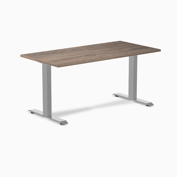 Desky Zero laminate office desk with a dark wood grain top and silver steel frame.