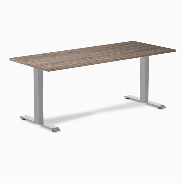Desky Zero fixed-height office desk with a dark wood laminate top and silver steel frame.