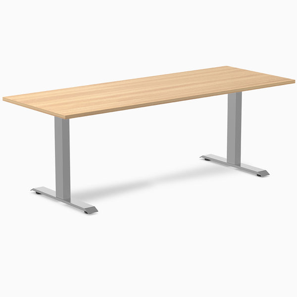 Desky Zero fixed height office desk with a light wood laminate top and silver steel frame.